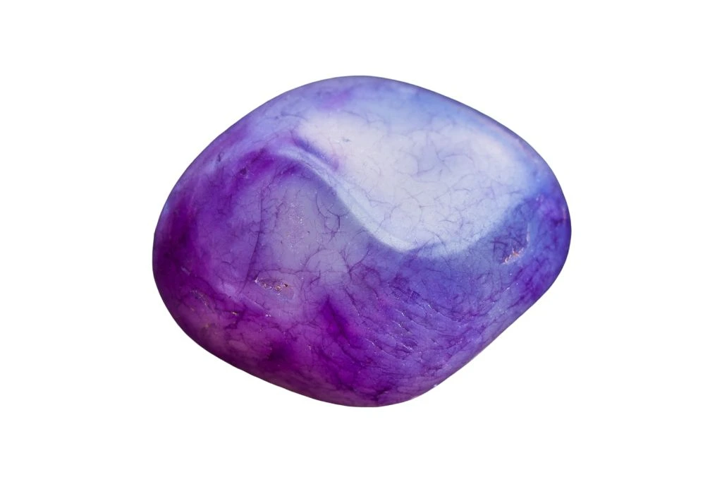 A tumbled Amethyst crystal on a white background